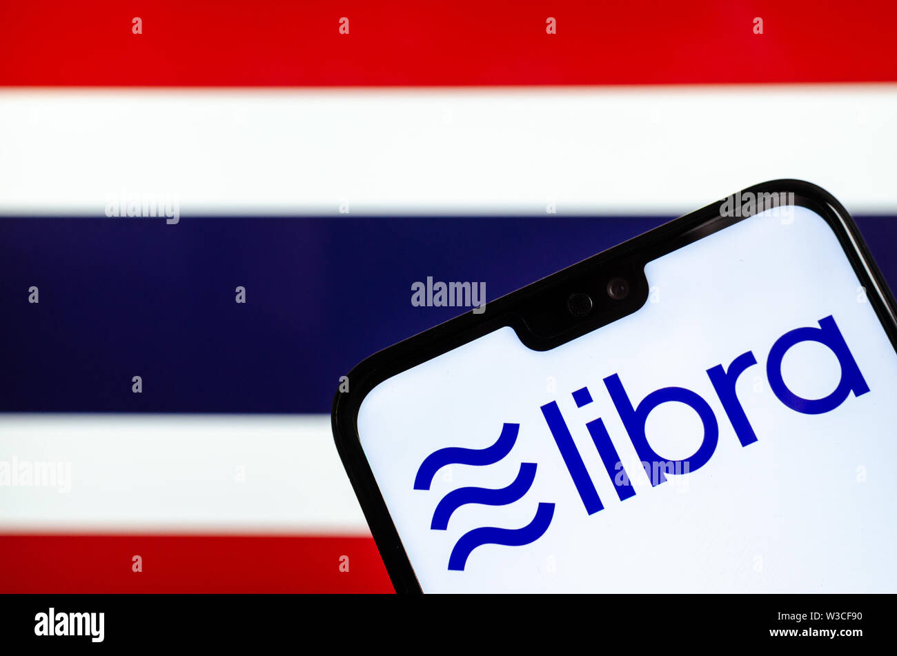 Facebook Libra crypto logo valuta sullo smartphone e sfocata bandiera della Thailandia a uno schermo portatile sullo sfondo. Foto concettuale. Foto Stock
