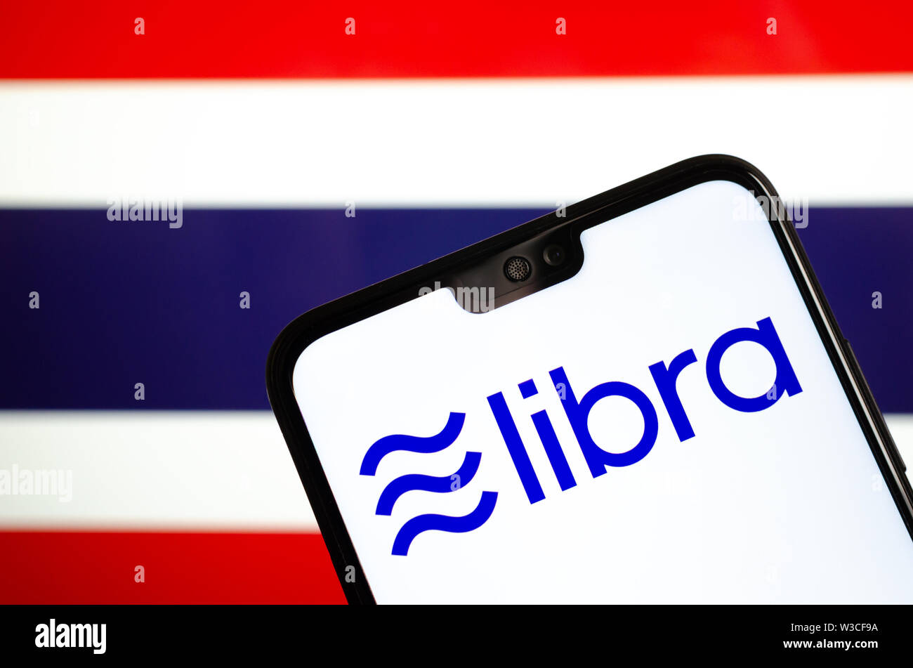 Facebook Libra crypto logo valuta sullo smartphone e sfocata bandiera della Thailandia a uno schermo portatile sullo sfondo. Foto concettuale. Foto Stock