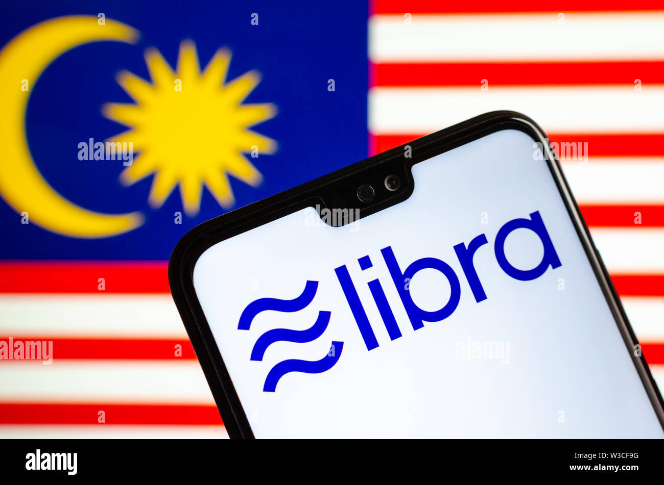 Facebook Libra crypto logo valuta sullo smartphone e sfocata bandiera della Malaysia a uno schermo portatile sullo sfondo. Foto concettuale. Foto Stock