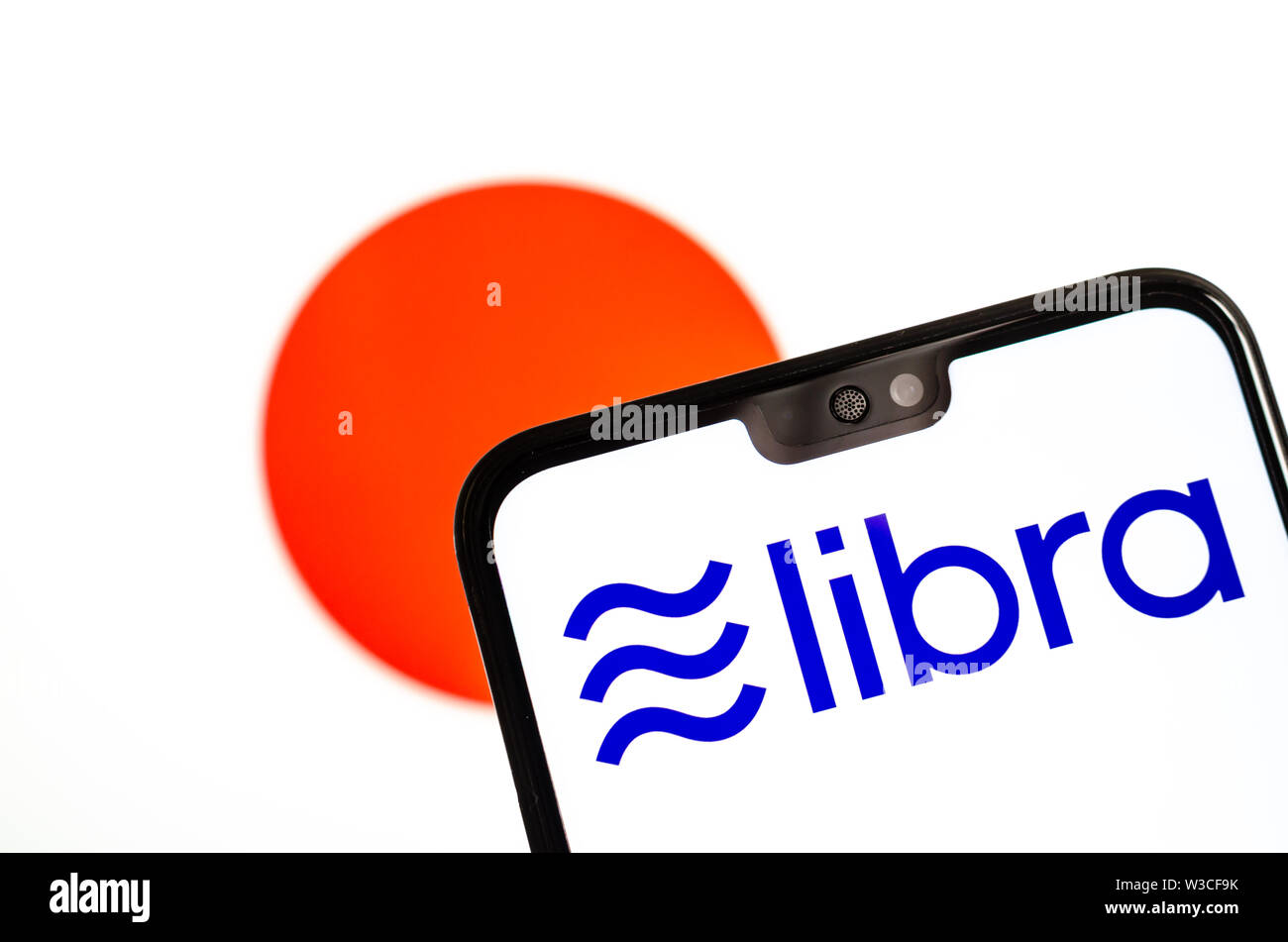 Facebook Libra crypto logo valuta sullo smartphone e sfocata bandiera del Giappone a uno schermo portatile sullo sfondo. Foto concettuale. Foto Stock