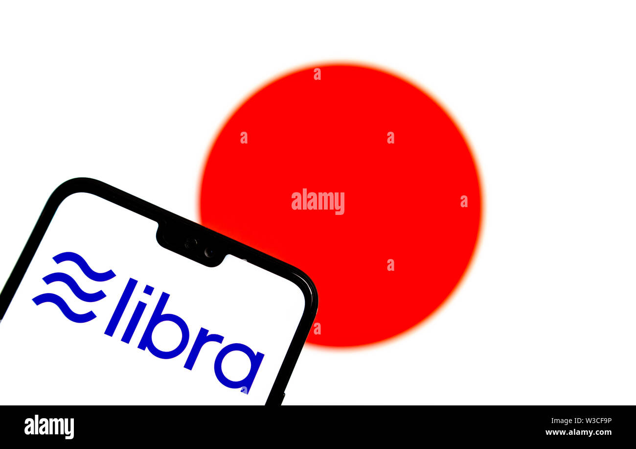 Facebook Libra crypto logo valuta sullo smartphone e sfocata bandiera del Giappone a uno schermo portatile sullo sfondo. Foto concettuale. Foto Stock