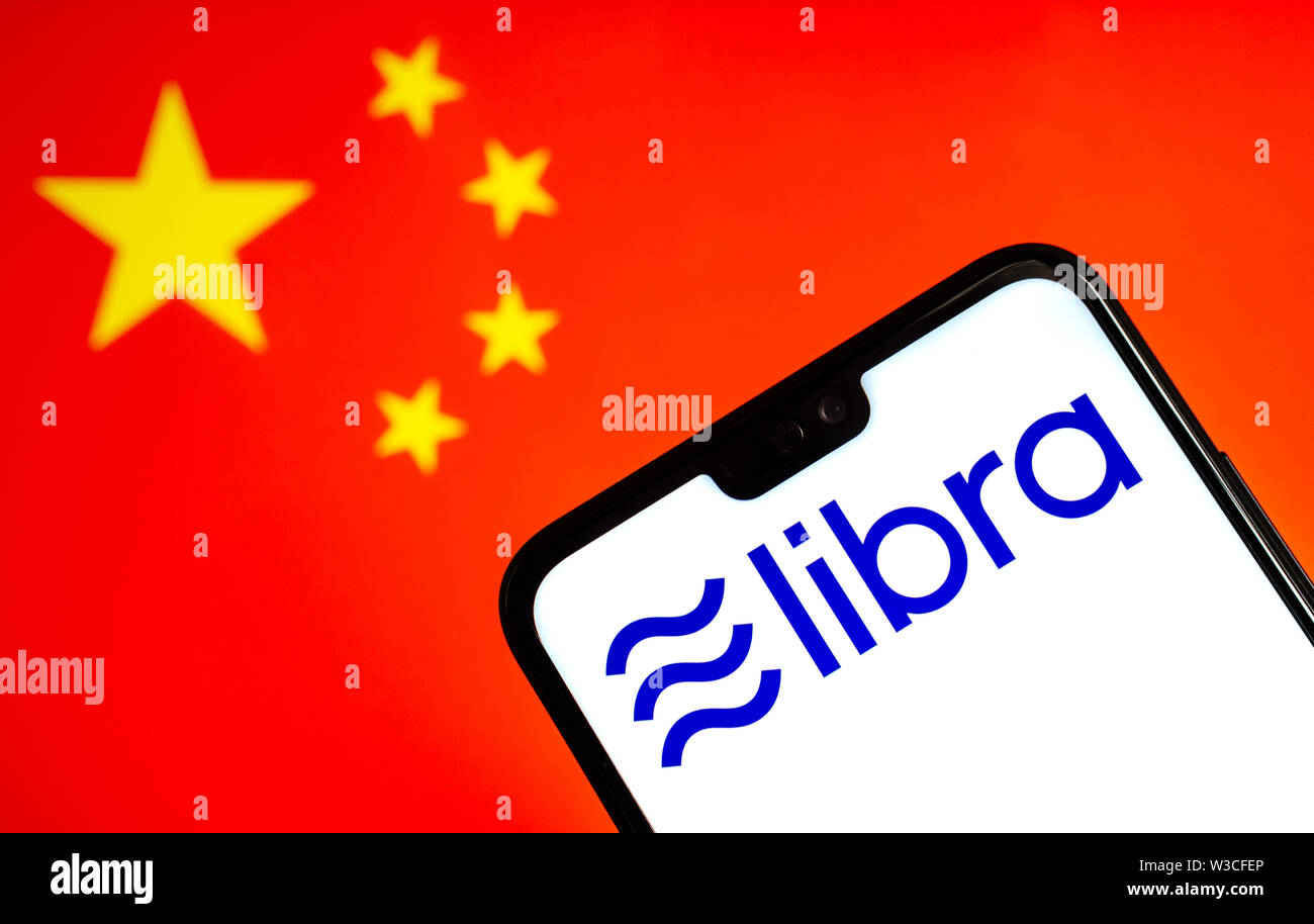 Facebook Libra crypto logo valuta sullo smartphone e sfocata bandiera della Cina a un portatile schermo sullo sfondo. Foto concettuale. Foto Stock