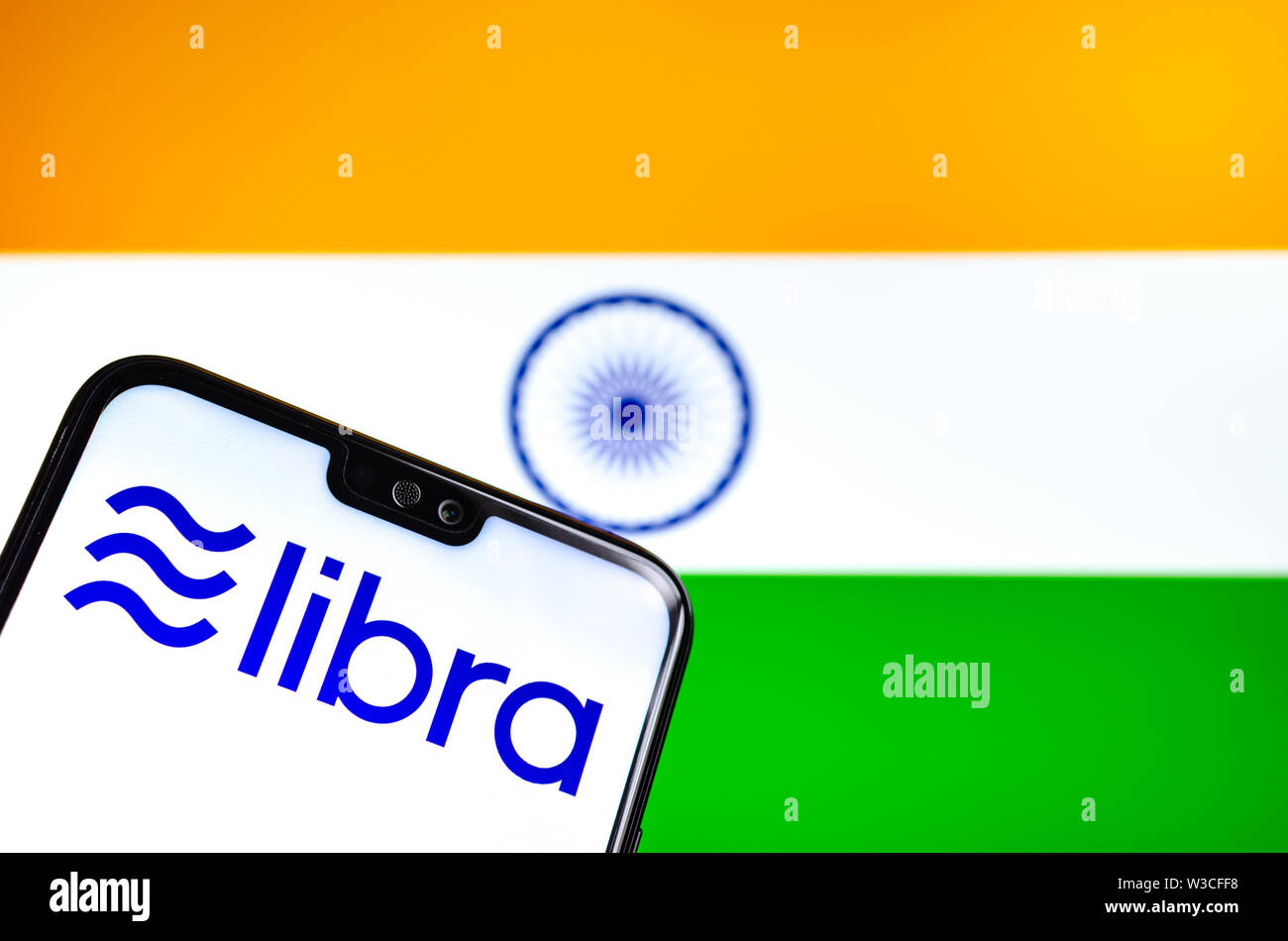 Facebook Libra crypto logo valuta sullo smartphone e sfocata bandiera dell India in una schermata di un laptop sullo sfondo. Foto concettuale. Foto Stock
