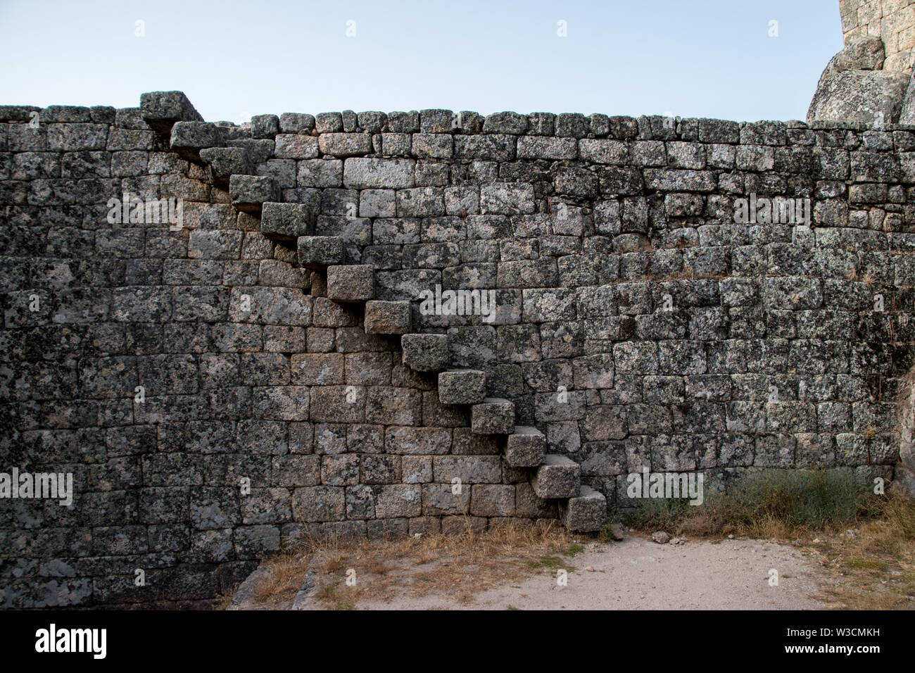 Una tromba delle scale piana sporgente da un muro di castello di Monsanto, Portogallo Foto Stock