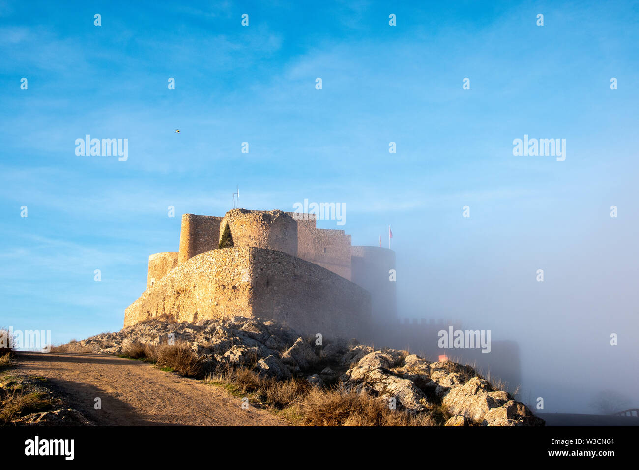 Il castello di Consuegra, Spagna metà nella nebbia. Il castello fu costruito su un antico fortilizio romano ed è stato usato durante la Reconquista. Foto Stock