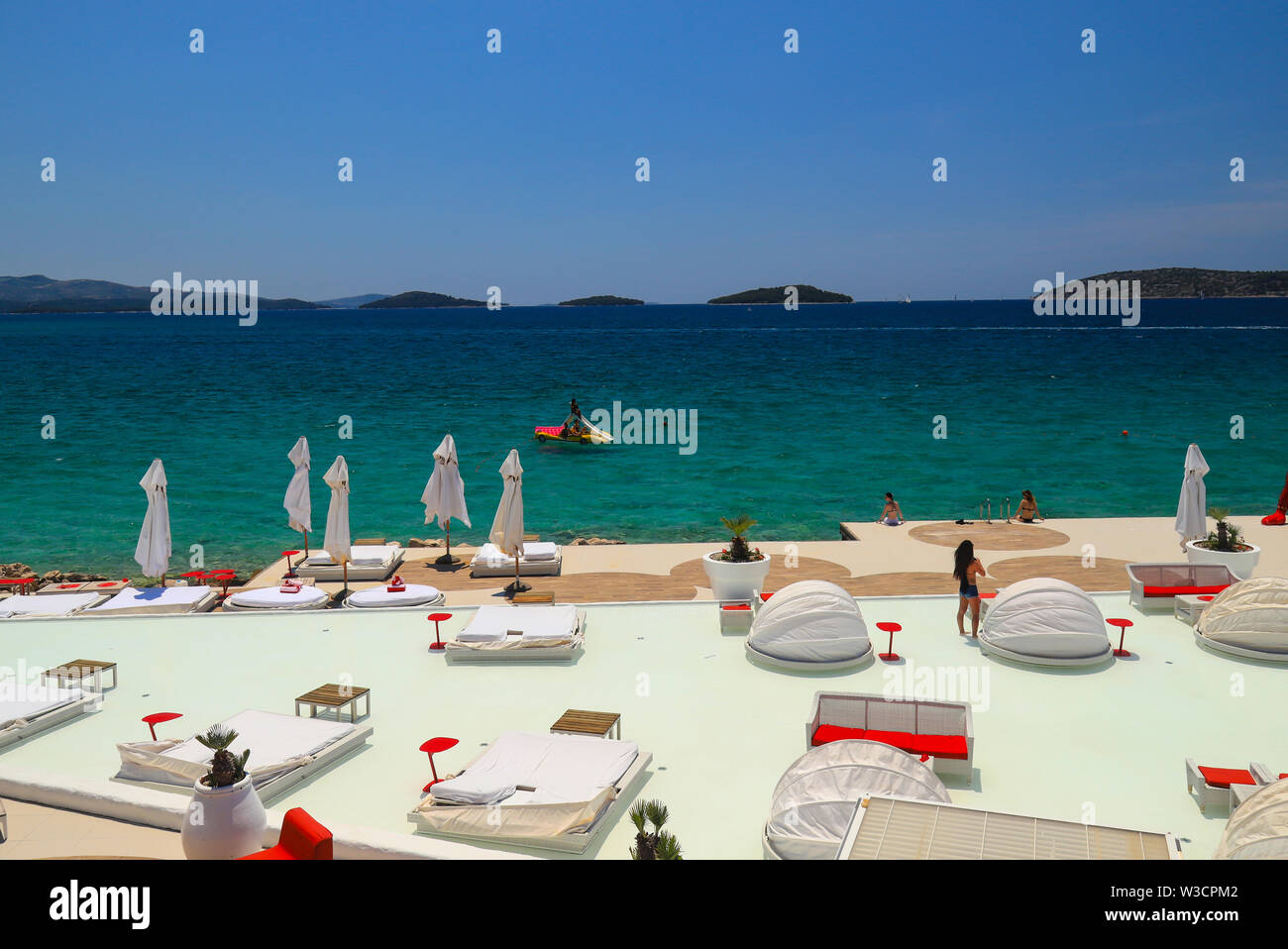 Bella estate panoramico con vista della spiaggia, la piscina di lusso. Moda bianco sdraio sulla spiaggia in riva al mare Foto Stock