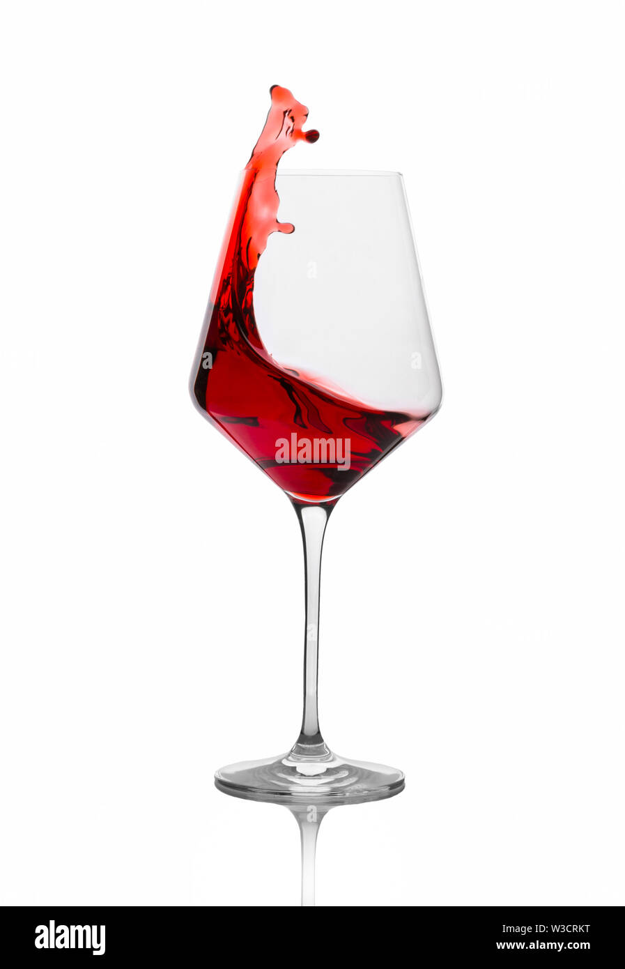 Vino rosso schizzi fuori di un vetro isolato su bianco Foto Stock