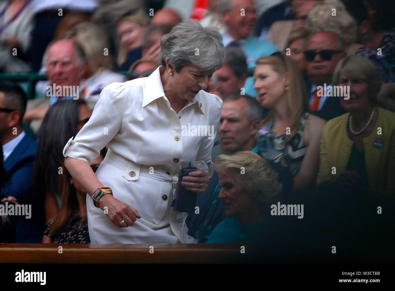 Il torneo di Wimbledon, Londra, Regno Unito. 13 luglio 2019. Il Primo Ministro inglese Theresa Maggio, (abito bianco) torna al suo posto dopo essere stato chiamato lontano durante la metà di guardare il Signore sceglie il finale tra Serena Williams e Simona Halep in campionati di Wimbledon tennis, Wimbledon, Londra sulla luglio 13, 2019 Credit: Paolo Marriott/Alamy Live News Foto Stock