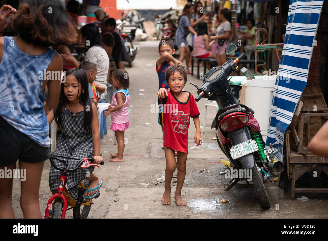Una tipica scena di strada all'interno di una comunità povera situato a Cebu City, Filippine Foto Stock