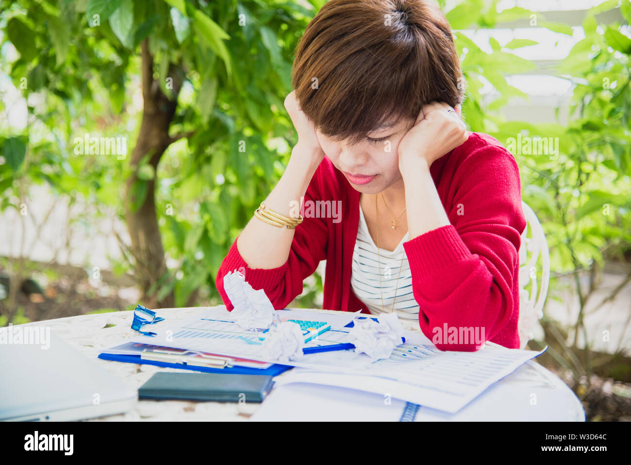 Vista superiore della giovane donna di lavoro utilizzando il laptop e la lettura di relazione annuale sul lavoro. Business donna lavora alla sua scrivania. Foto Stock