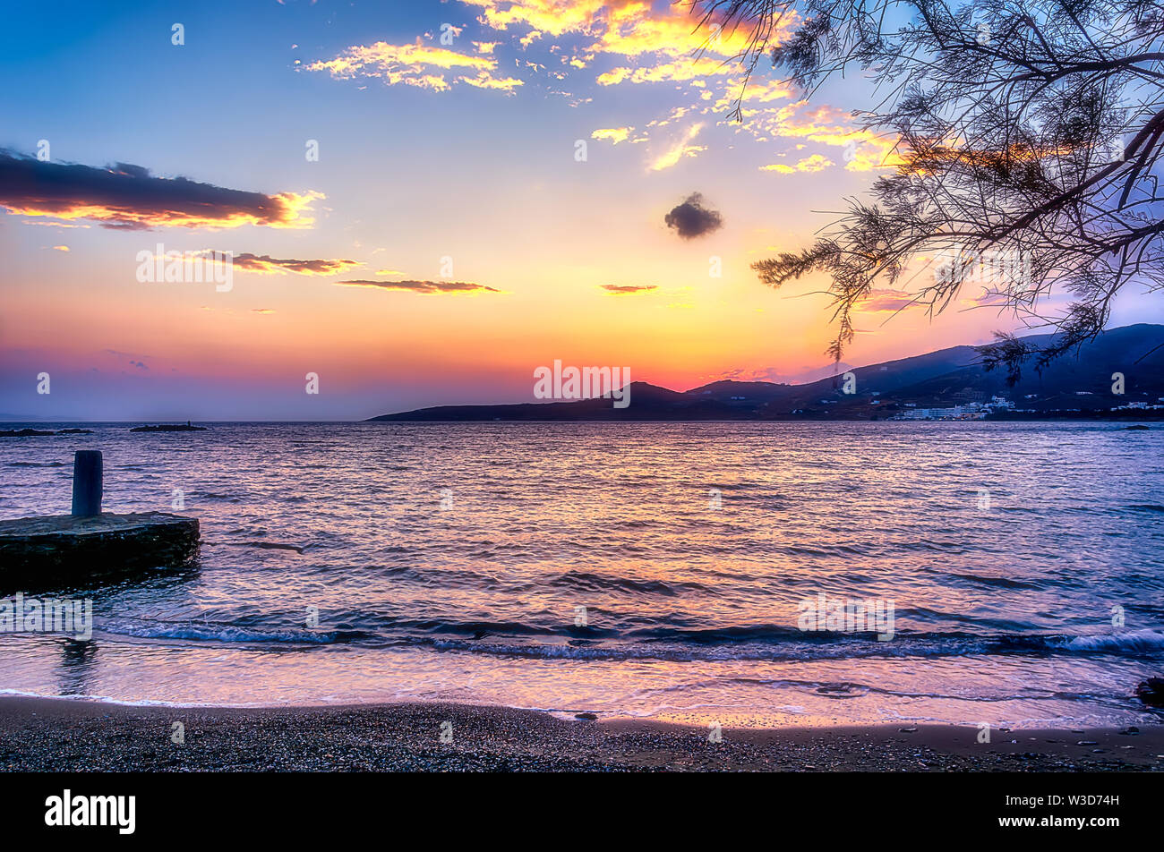 Tramonto sulla isola di Tinos, Grecia. Vista dalla spiaggia. Foto Stock