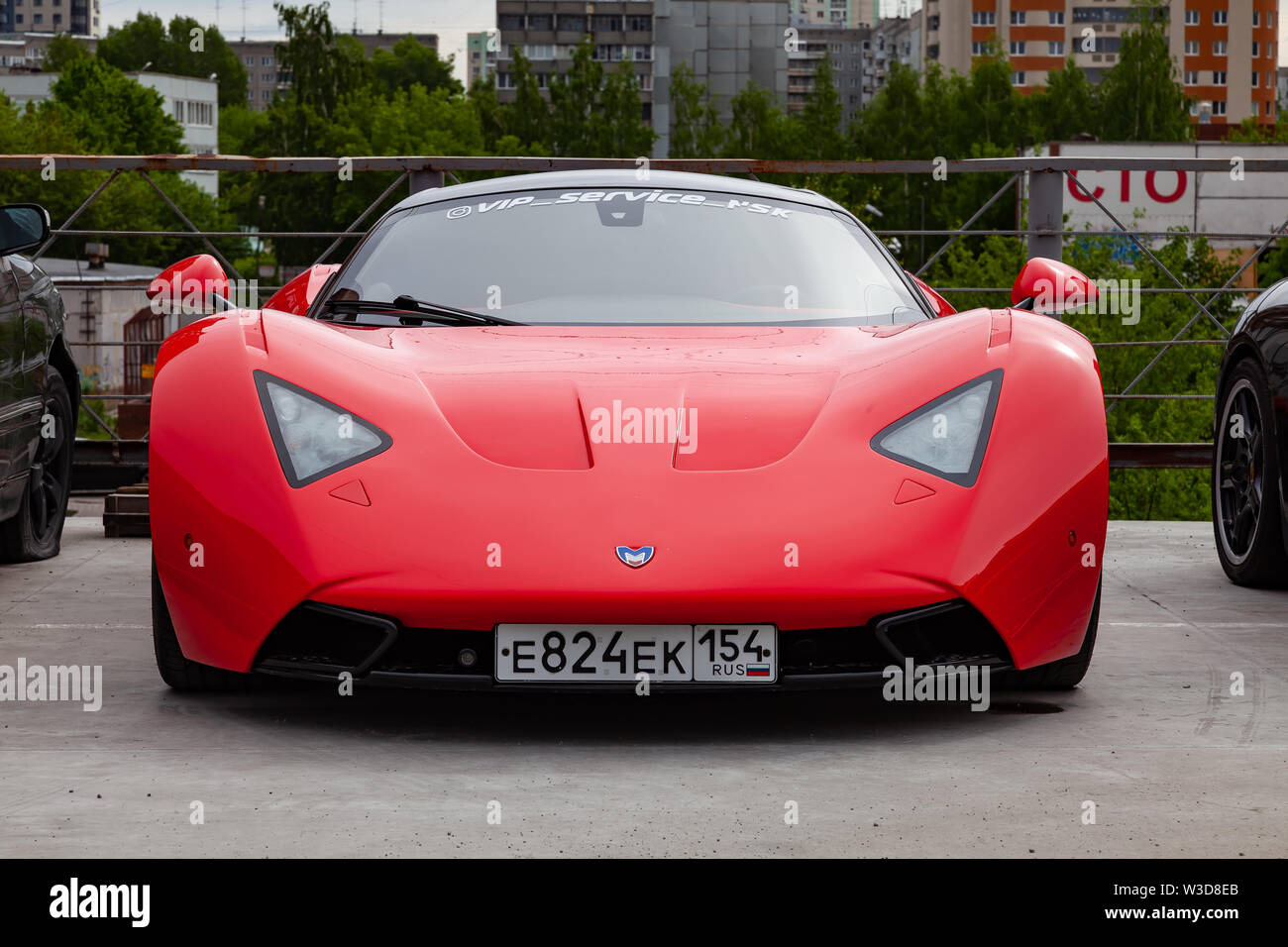 Novosibirsk, Russia - 07.13.2019: Marussia Motors modello B1 in colore rosso e il tetto nero vista frontale. La fotografia di un russo supercar vicino ai concessionari Foto Stock