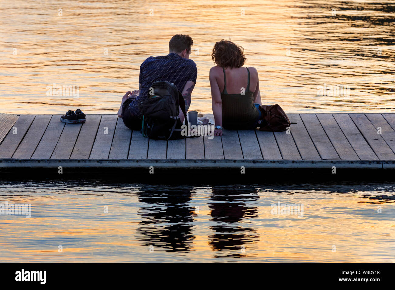 Un giovane su un dock, tramonto, Esplanade, Charles River, Boston Massachusetts Foto Stock