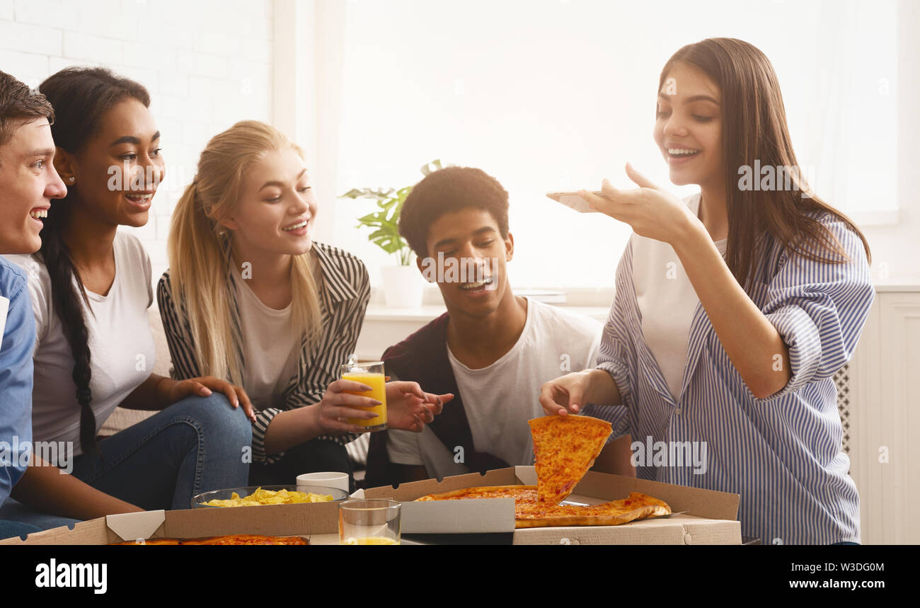 Teen blogger prendendo foto di pizza, avente home party Foto Stock