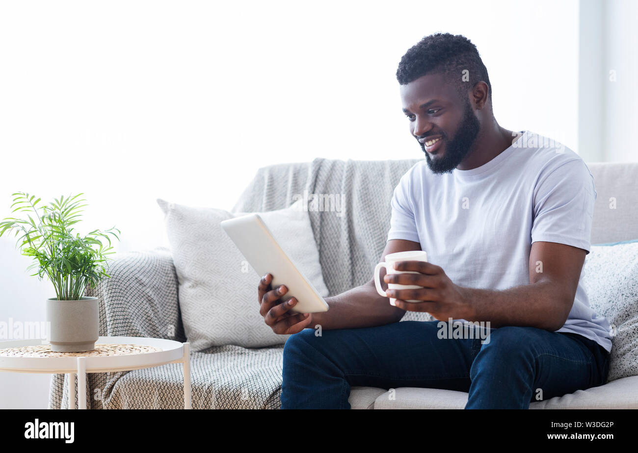 African American uomo guardando film su tablet in ambienti interni Foto Stock
