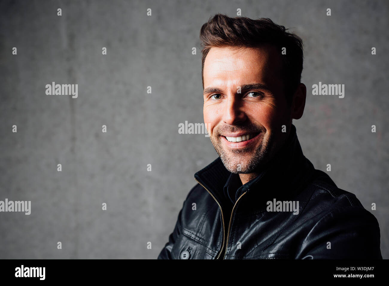 Ritratto di felice uomo bello in giacca di pelle Foto Stock