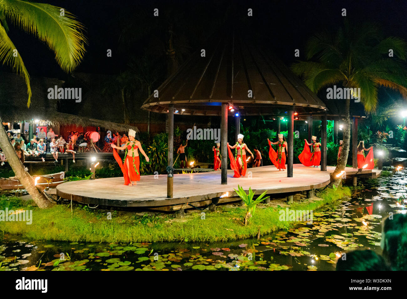 Le donne polinesiane danza su un palco galleggiante presso la popolare spettacolo turistico di Te Vara Nui Village, la festa, Rarotonga Isole Cook, Polinesia Foto Stock