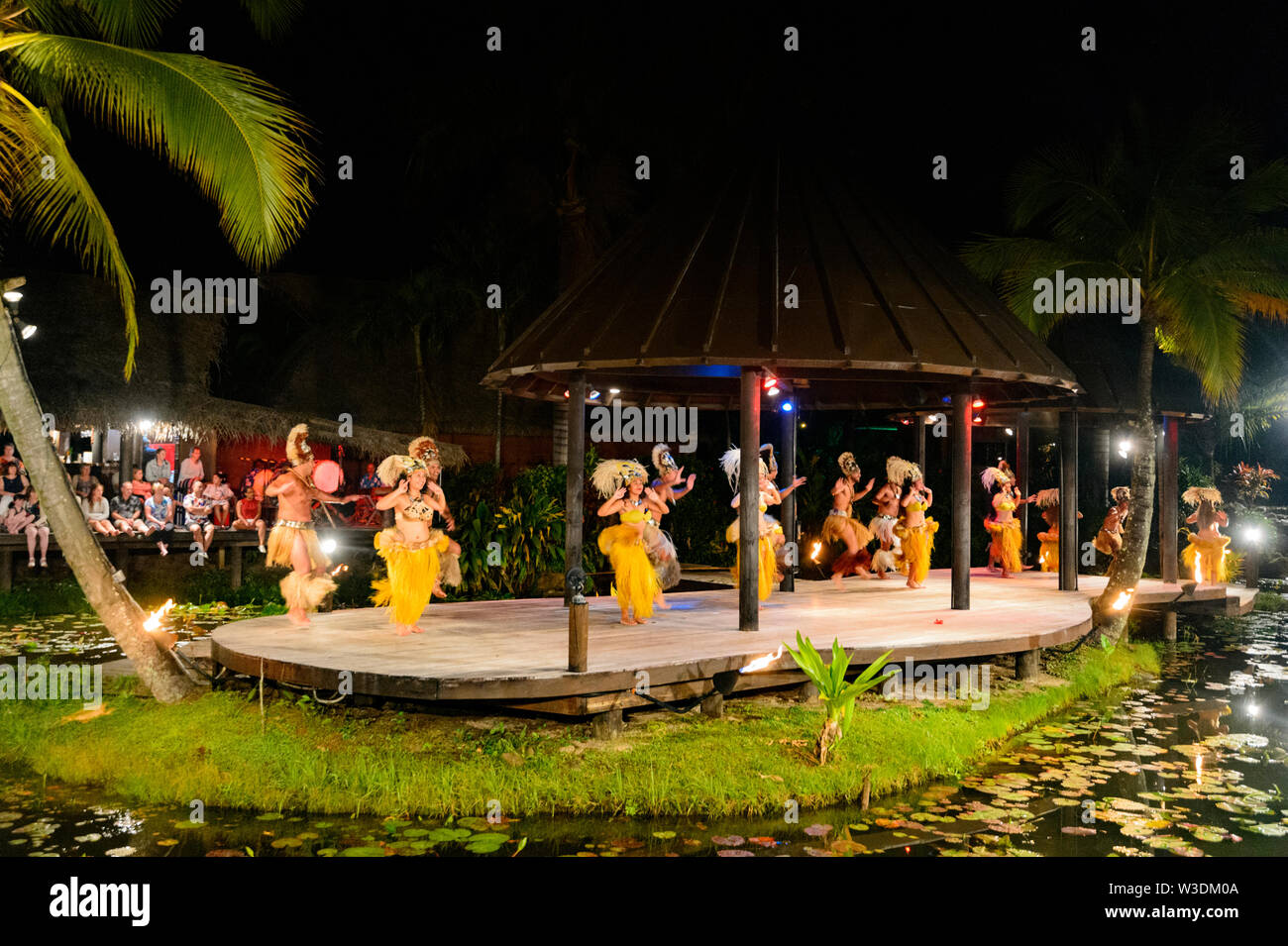 Gruppo di ballerini polinesiano di eseguire su un palco galleggiante presso la popolare spettacolo turistico di Te Vara Nui Village, la festa, Rarotonga Isole Cook, P Foto Stock