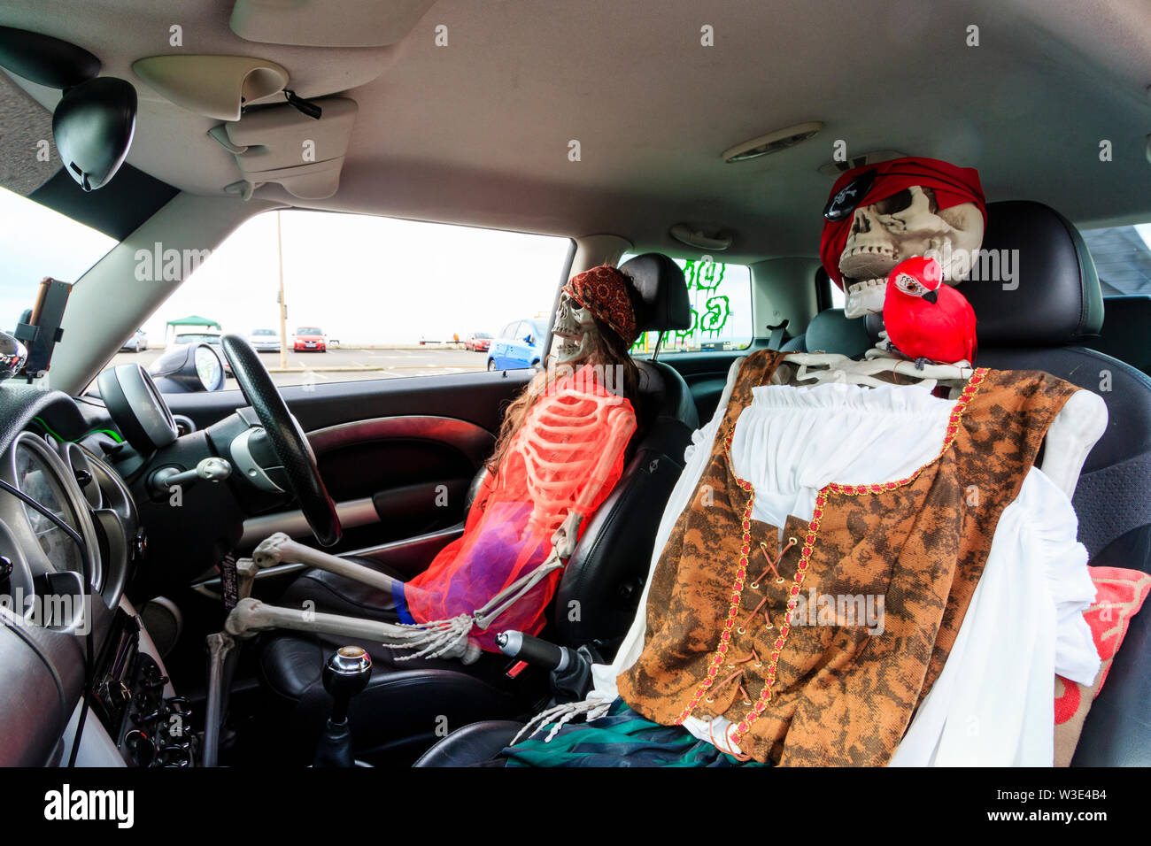 Interno del mini auto con due figure di scheletro, vestito come pirati, seduta del conducente e dei passeggeri posti come se la guida. Giornata dei Pirati, Hastings. Foto Stock
