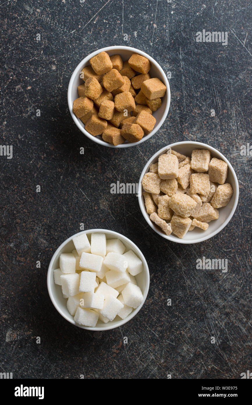 Bianco e Marrone di cubetti di zucchero in ciotole. Vista dall'alto. Foto Stock