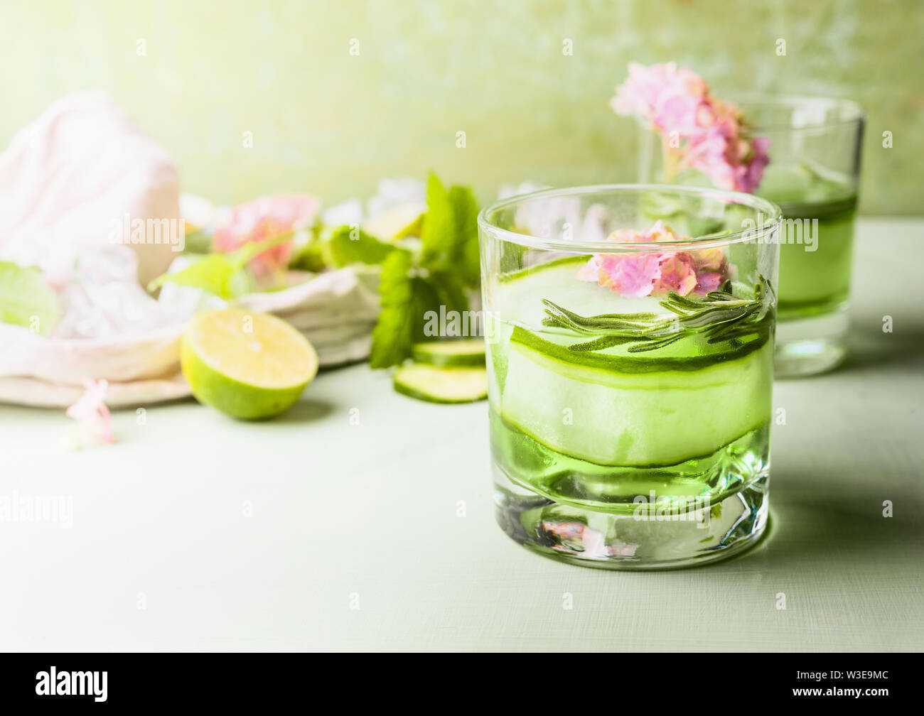 Vetro con iced verde lime cetriolo bevanda rinfrescante sul tavolo luminoso in corrispondenza della parete dello sfondo. Estate bevande concetto. Colore verde . Sana limone fatti in casa Foto Stock