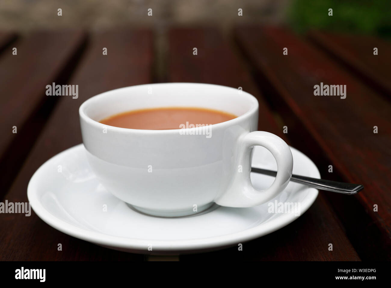 Una tazza di tè su un tavolo da giardino Foto Stock