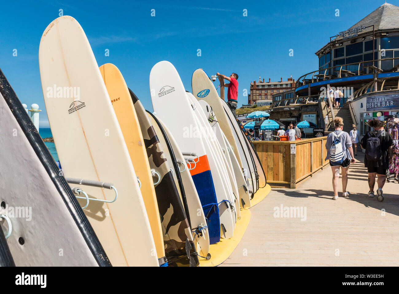 Tavole da surf sono disponibili al noleggio impilati a Fistral Surf Noleggio a Newquay in Cornovaglia. Foto Stock