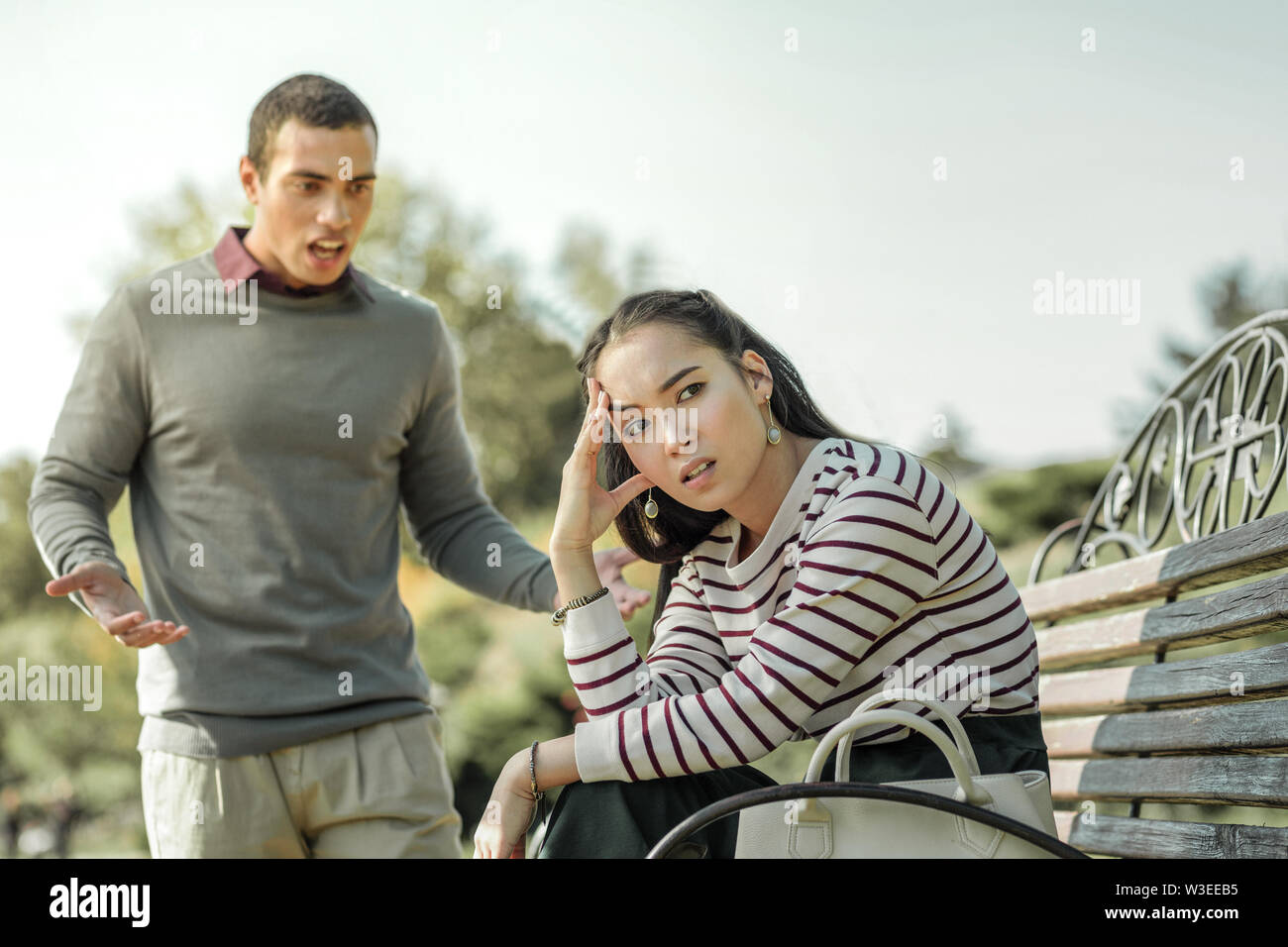 Espressivo dai capelli scuri gridare l uomo sulla sua ragazza Foto Stock