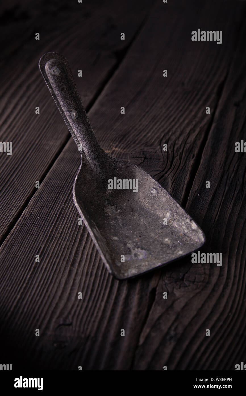 Pala di ferro su una tavola di legno, materiale naturale villaggio. La cucina è una buona idea. Foto Stock