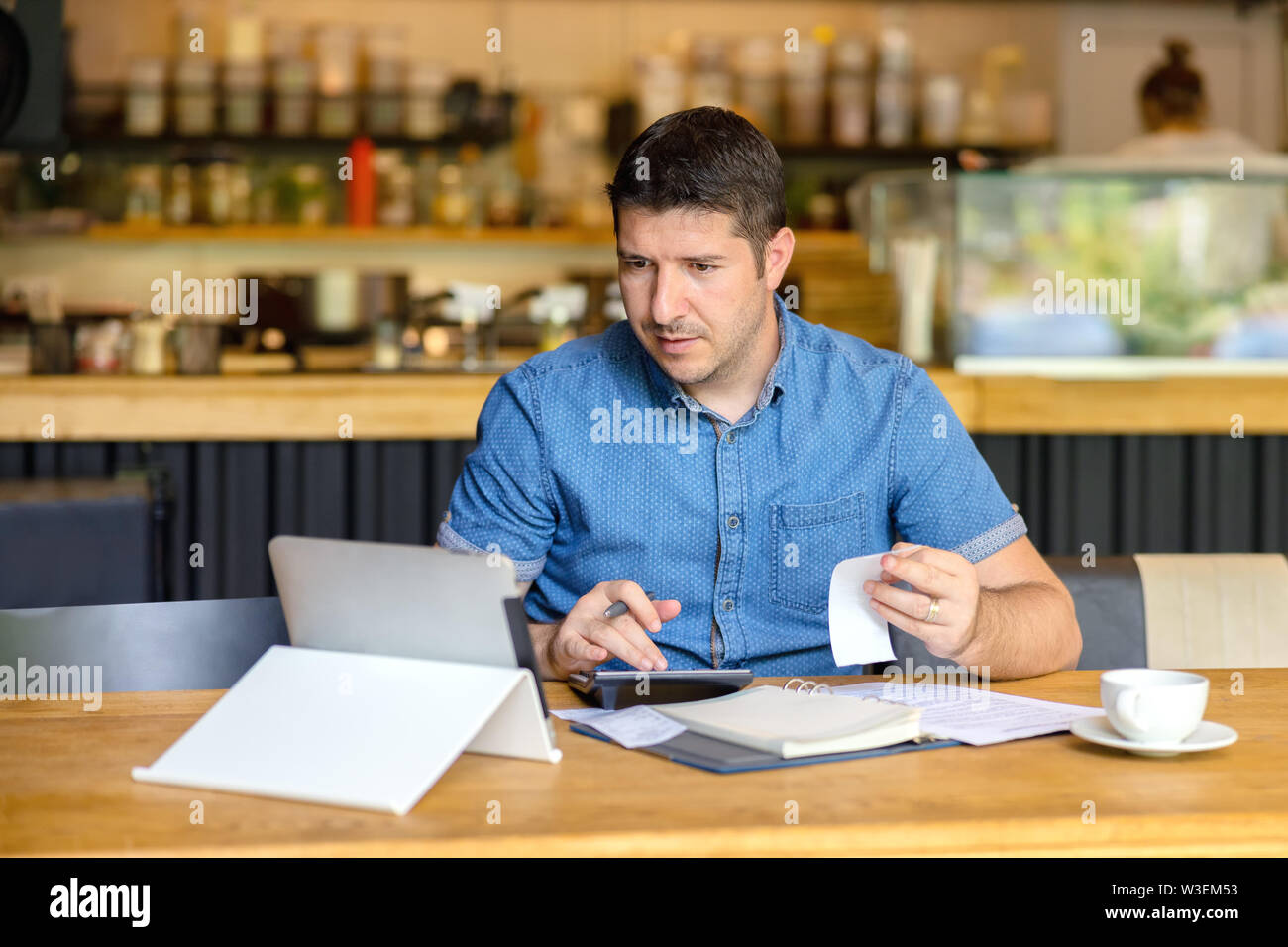 Coppia titolare di azienda con tavoletta digitale calcolando il profitto del nuovo business Foto Stock