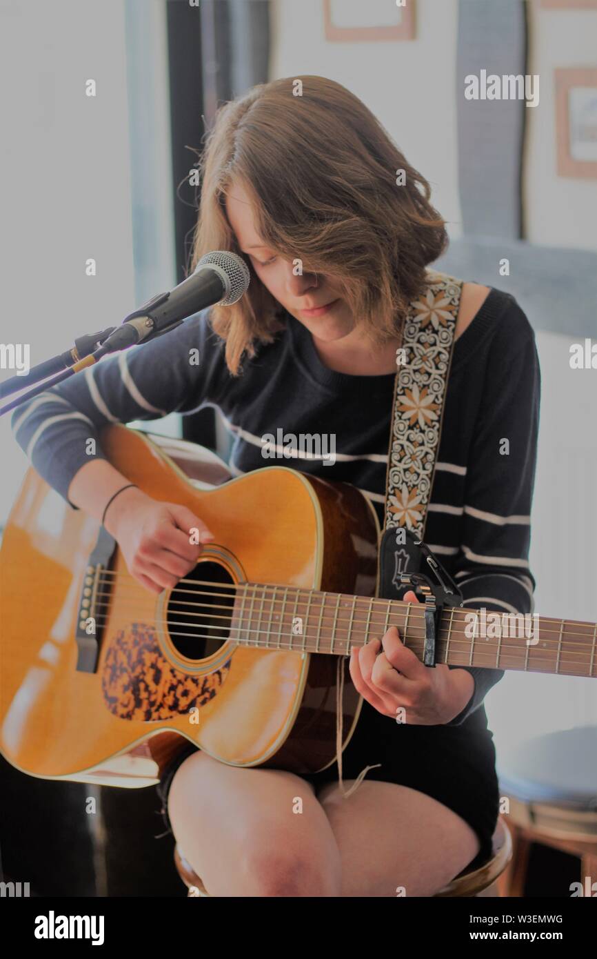 La donna a suonare la chitarra Foto Stock