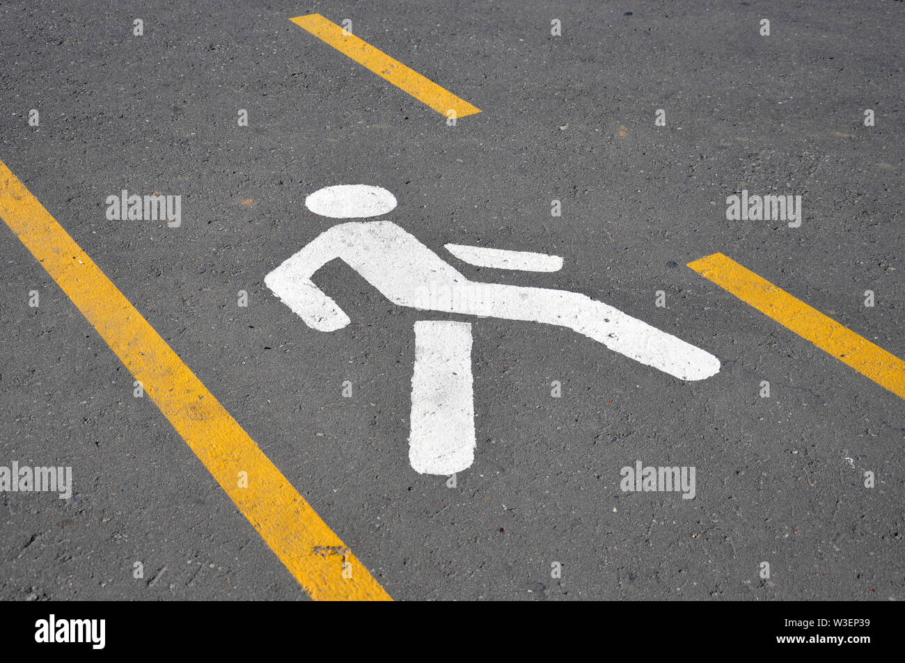 Crosswalk. La segnaletica stradale in forma di una figura umana e linee di colore giallo Foto Stock