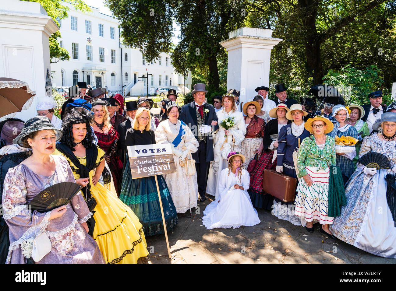 Broadstairs Dickens Festival. Foto di gruppo di molte persone vestite nel periodo Vittoriano costume disposti in un semicerchio in posa davanti mansion. Foto Stock
