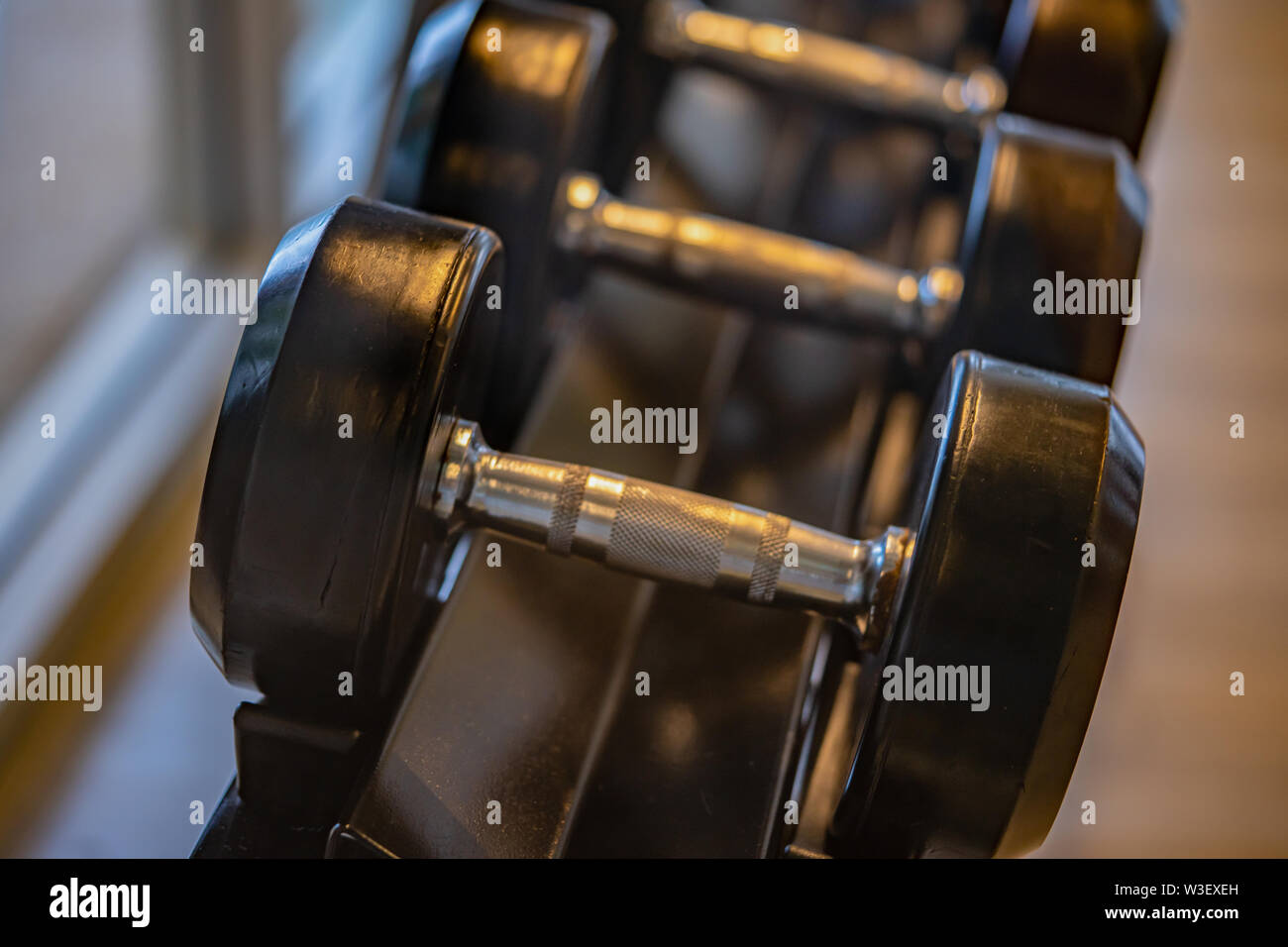 Nero set di manubri. Chiudere molti pesi di metallo sulla cremagliera in sport centro fitness , Peso attrezzature di formazione del concetto. Foto Stock