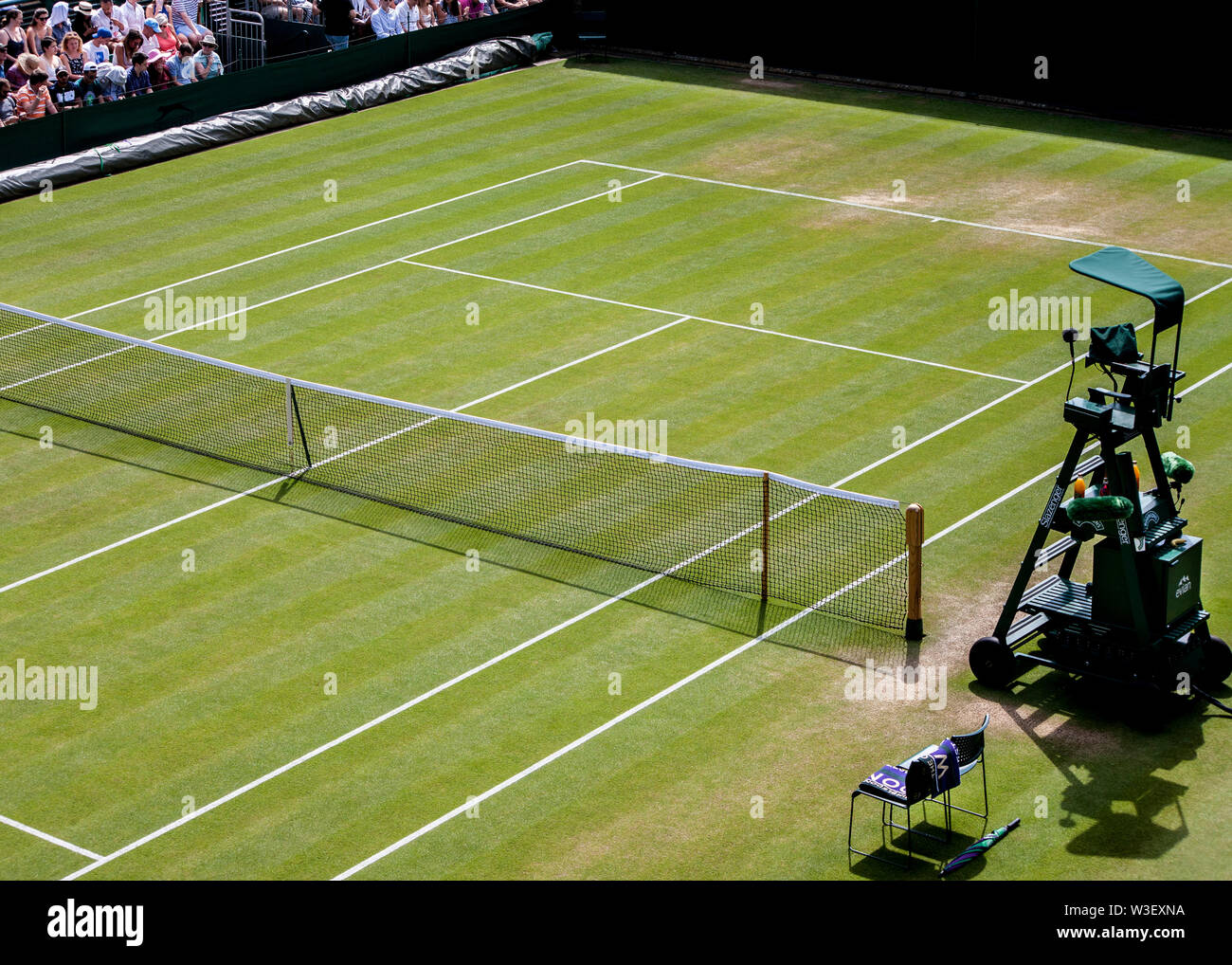 Svuotare il campo da tennis pronto per i giocatori e i funzionari wimbledon 2019 Vuoto umpire del tennis sedia in attesa in corrispondenza del bordo della corte a Wimbledon Foto Stock