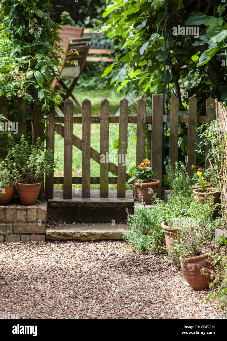 Il giardino inglese scena, cancello in legno con tavolo e sedie, Foto Stock