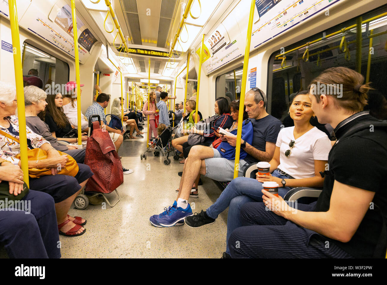 Carrozza metropolitana di Londra all'interno; passeggeri seduti in carrozza con un treno della metropolitana Circle Line di Londra, Londra UK Foto Stock