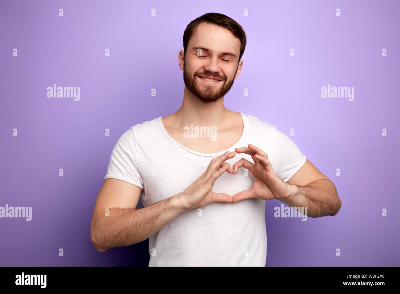 Uomo romantico che mostra il suo amore per una ragazza, una forte sensazione di caldo. close up ritratto, affetto . l uomo con gli occhi chiusi esprime il suo sentimento. isolare Foto Stock