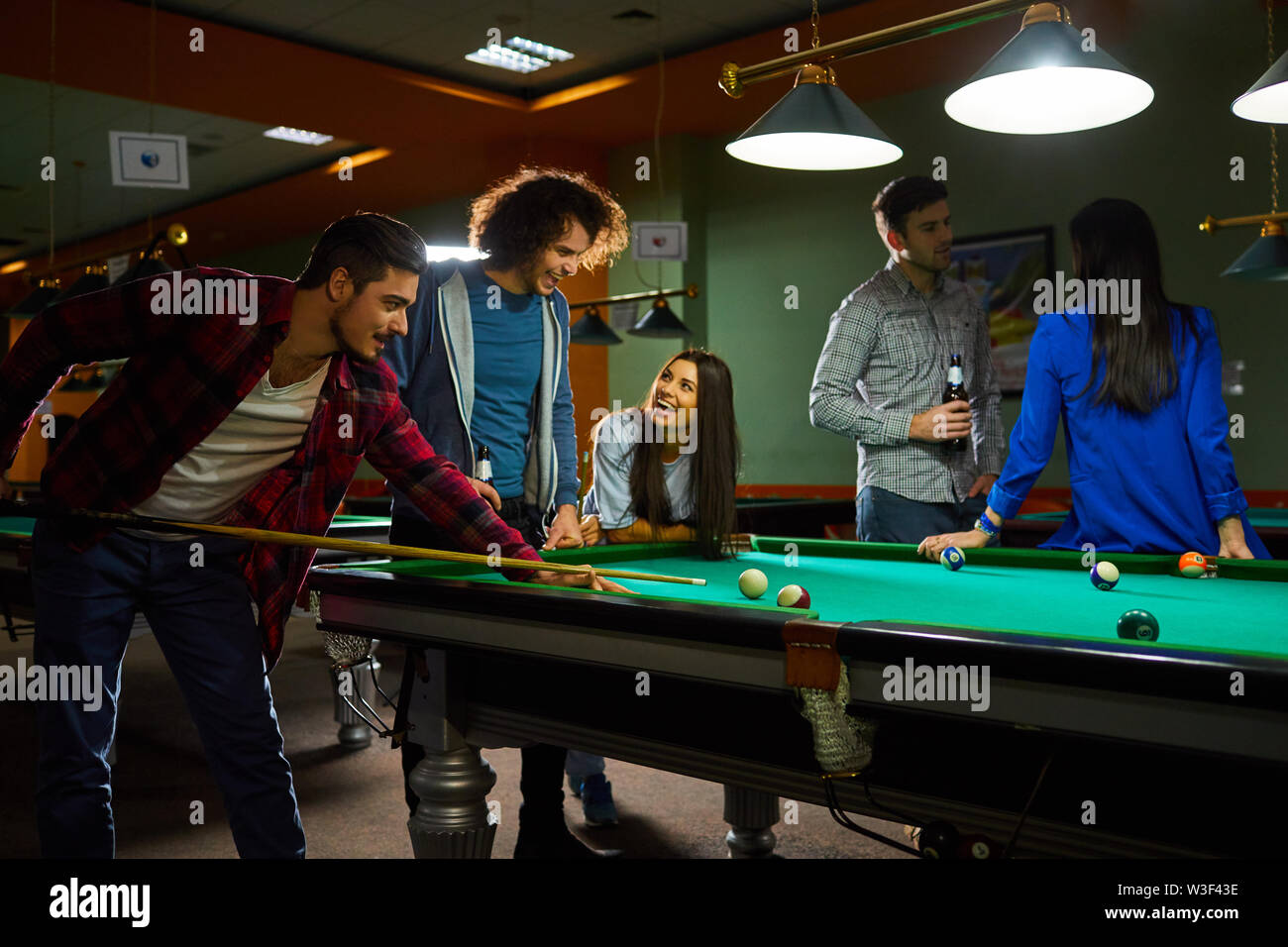I giovani di giocare a biliardo. Un gruppo di giovani divertimento giocando a biliardo. Foto Stock