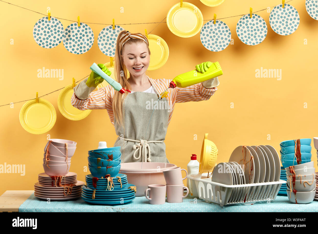 Una donna con un grembiule giallo è in piedi davanti al bancone della cucina.
