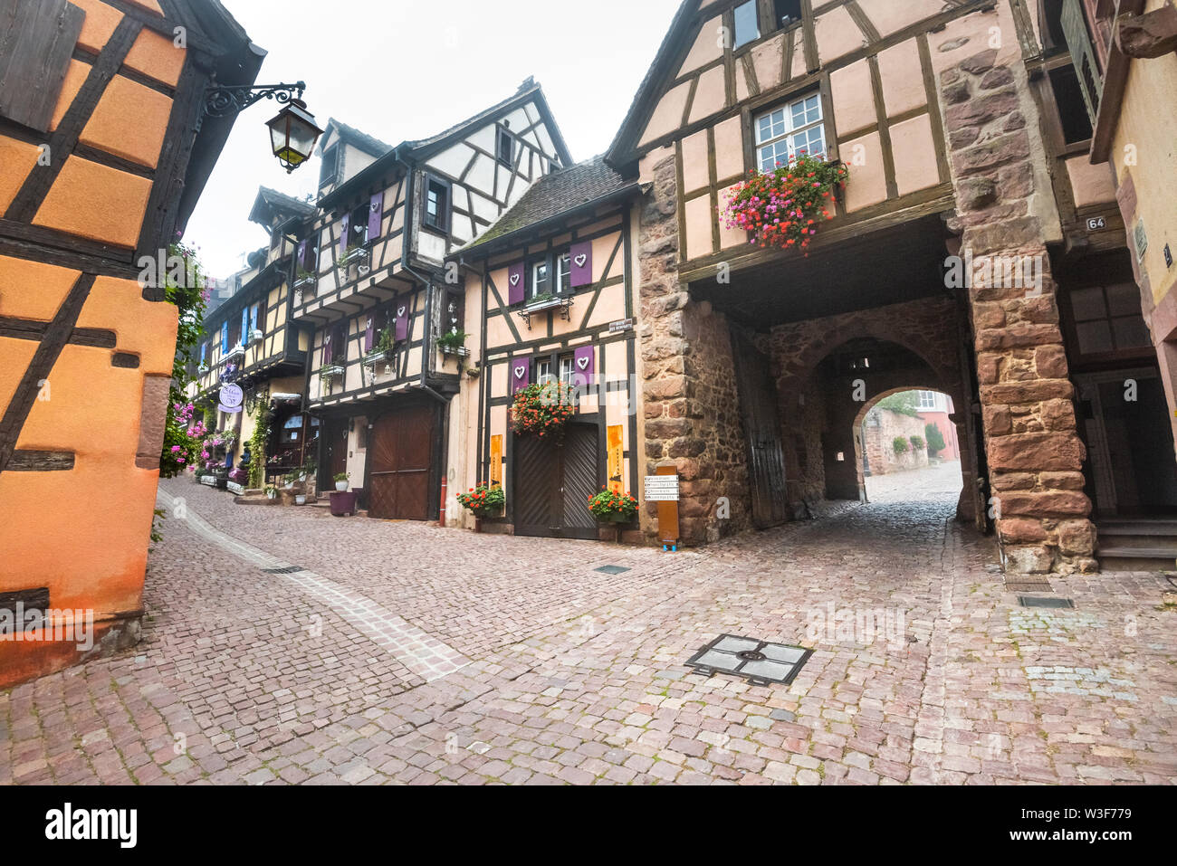 Vecchio tipiche case a graticcio in Riquewihr con town gate, Alsazia strada del vino, Francia, turistica sito medievale Foto Stock