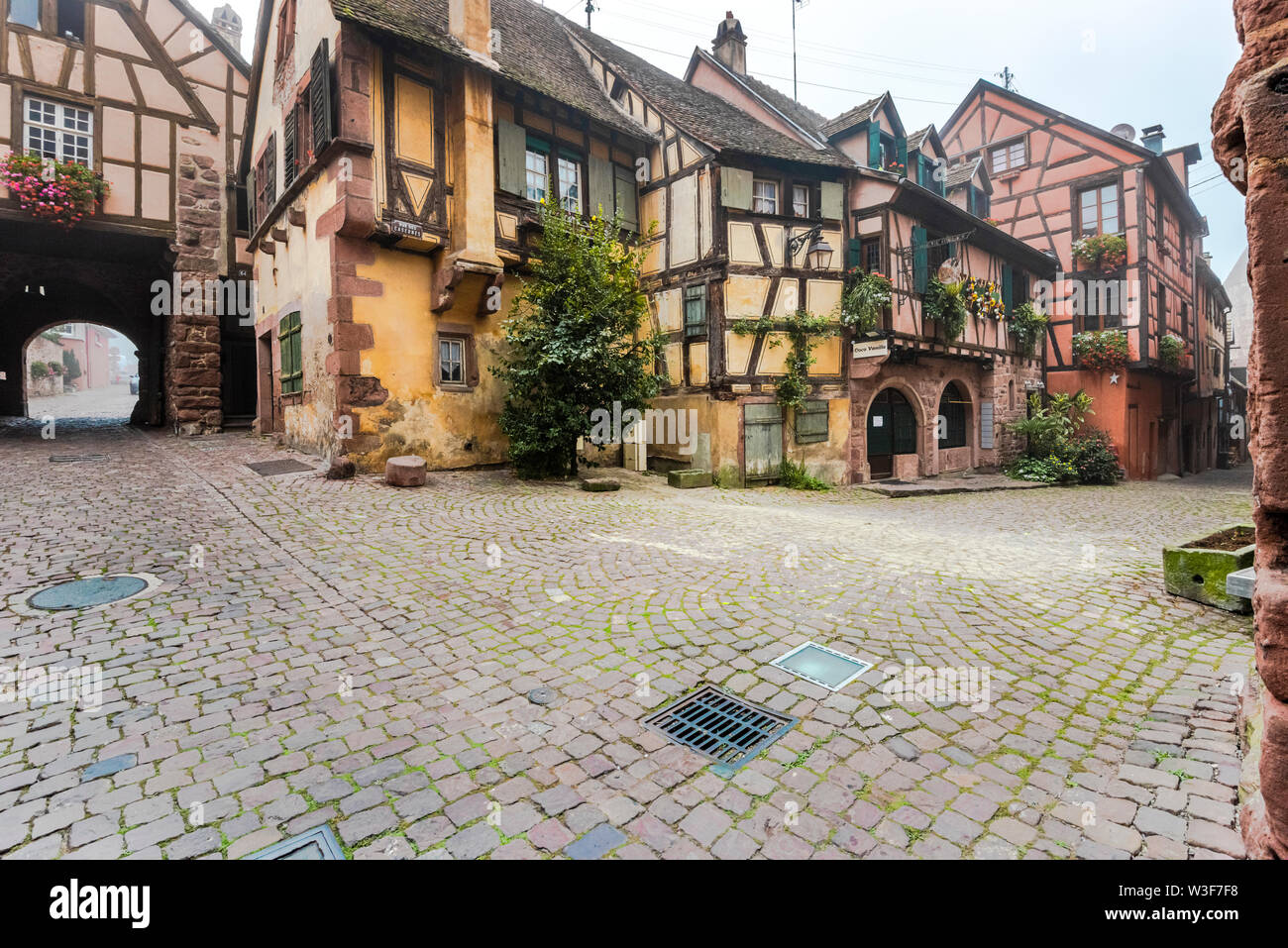 Scenic ensemble con tipiche case a graticcio in Riquewihr, Alsazia strada del vino, Francia, borgo medievale e destinazione turistica Foto Stock