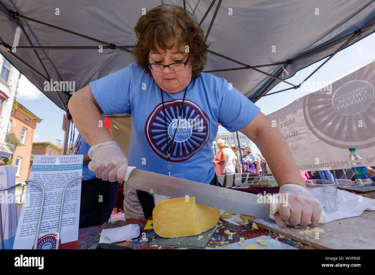 Donna tagli di formaggio artigianale presso l annuale Little Falls Festa del formaggio nella contea di Herkimer, New York, Stati Uniti d'America Foto Stock