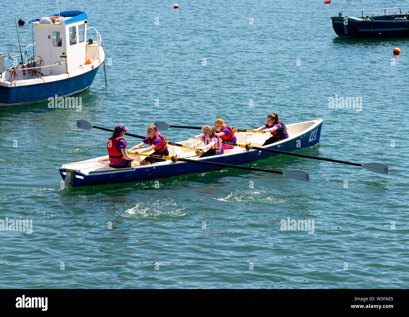Bambini canottaggio in una fascia costiera di regata di canottaggio Foto Stock
