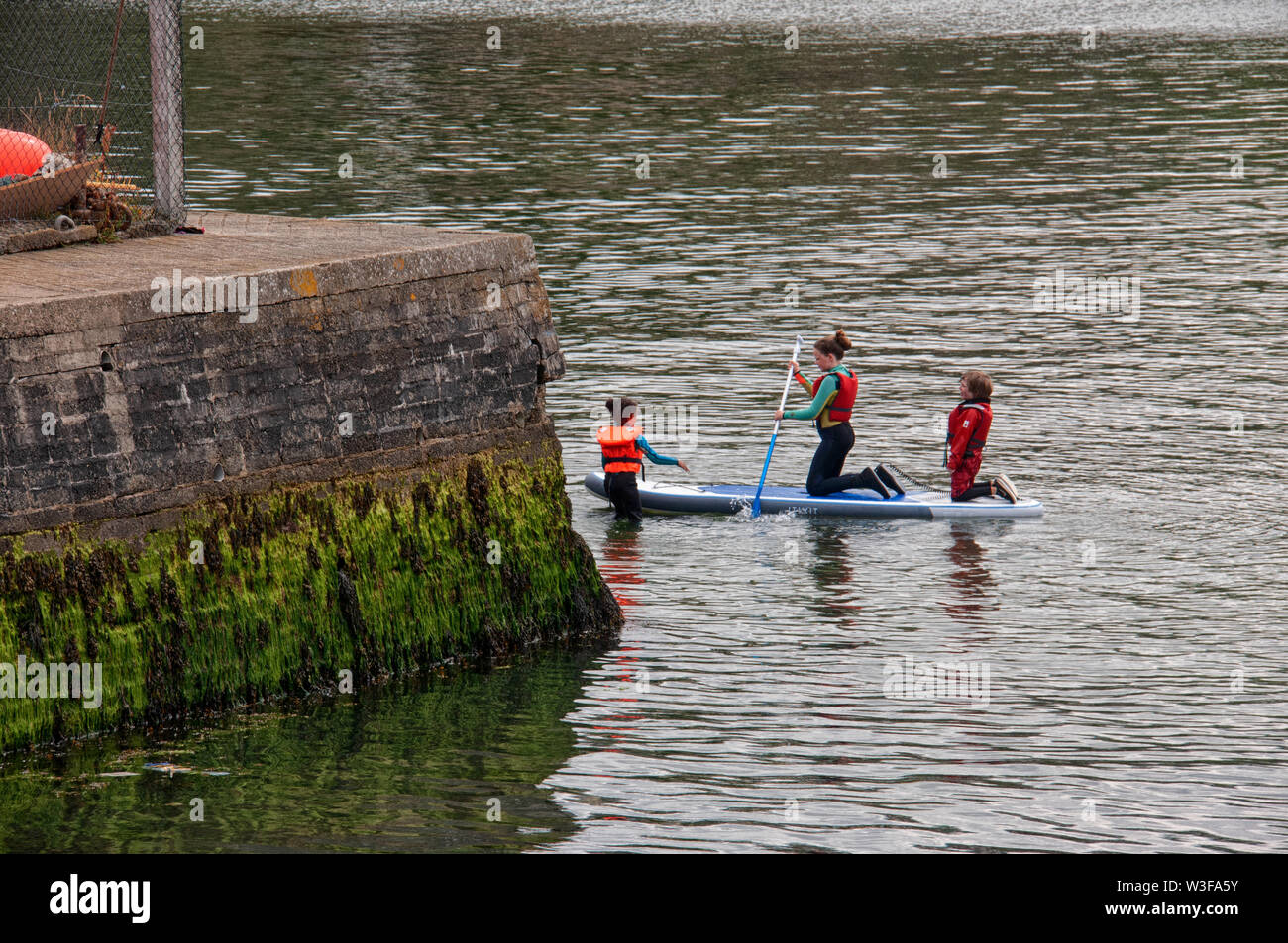 Un gruppo di ragazze paddle imbarco in Wicklow Porto sulla costa irlandese Foto Stock