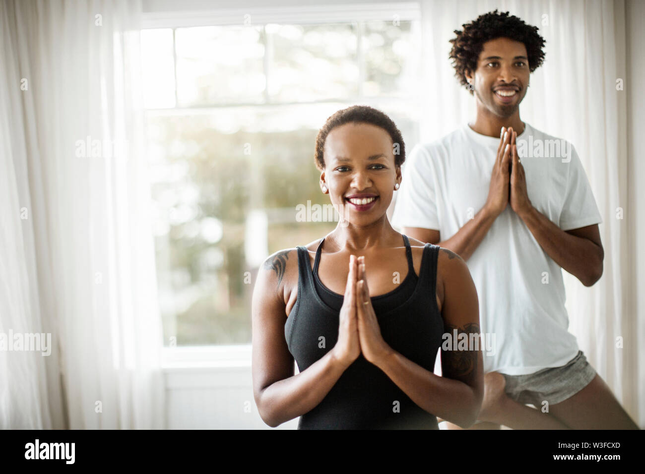 Sorridente giovane a praticare yoga insieme. Foto Stock