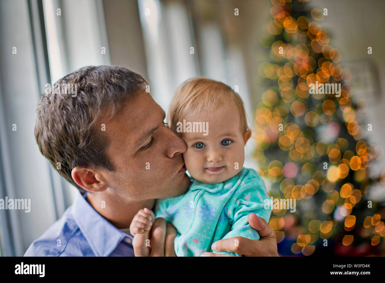 Padre baciare la sua bimba a Natale. Foto Stock