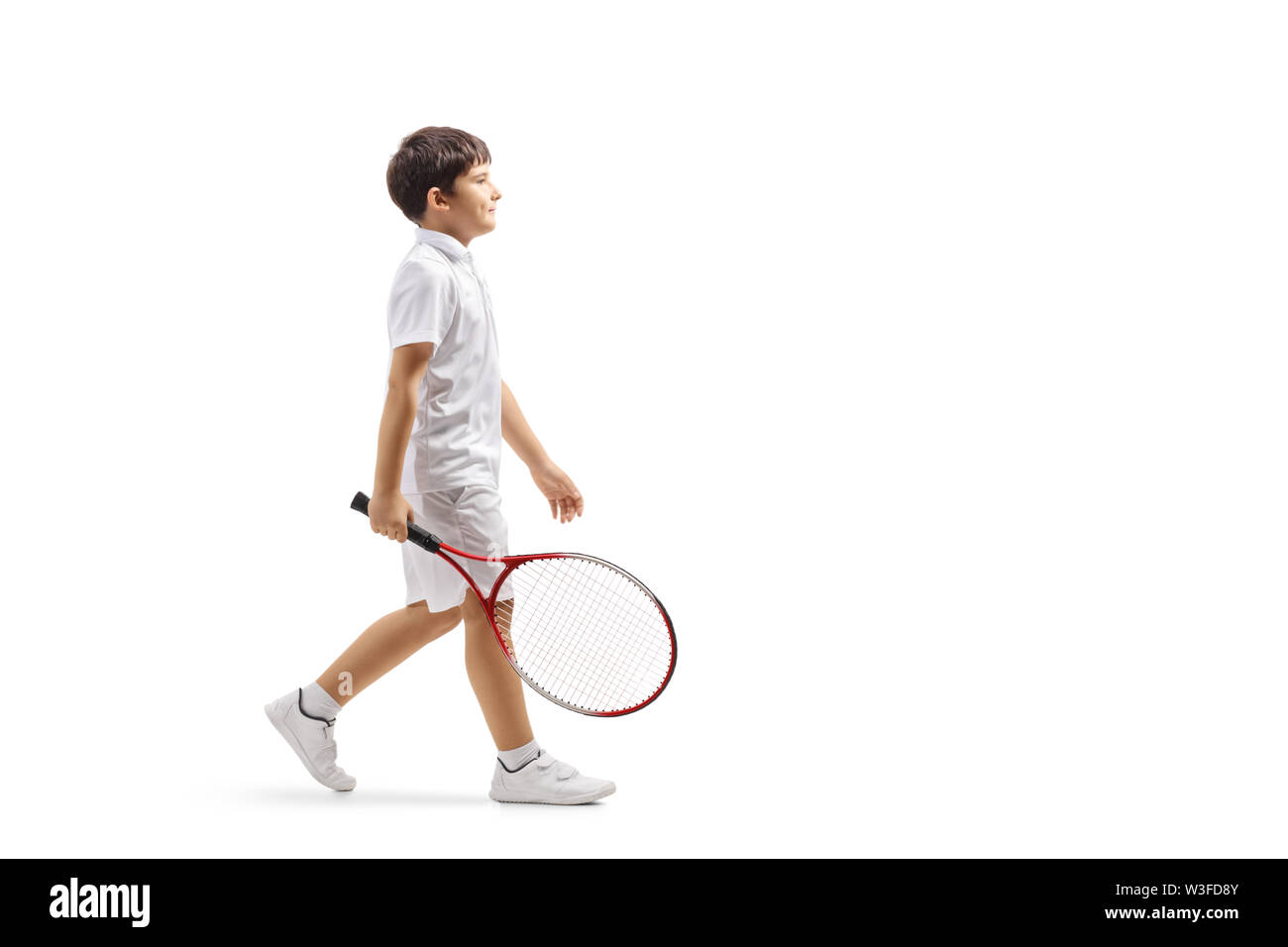 Lunghezza piena ripresa del profilo di un ragazzo con una racchetta da tennis camminare isolati su sfondo bianco Foto Stock