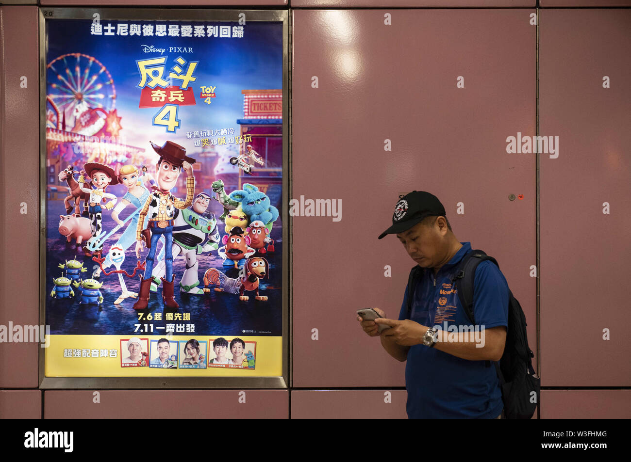 Luglio 12, 2019 - Hong Kong, Cina - un " commuter " sorge accanto alla Pixar Animation Studios Toy Story 4 movie annuncio a Hong Kong MTR stazione della metropolitana. (Credito Immagine: © Budrul Chukrut/SOPA immagini via ZUMA filo) Foto Stock