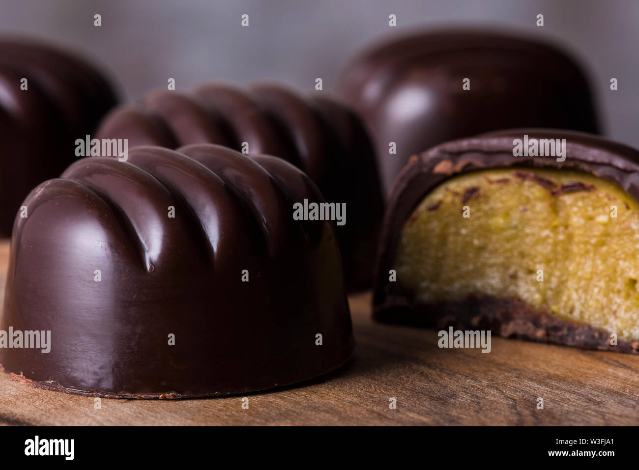 Dark, stampato cioccolatini ripieni di marzapane al pistacchio di riempimento. Foto Stock